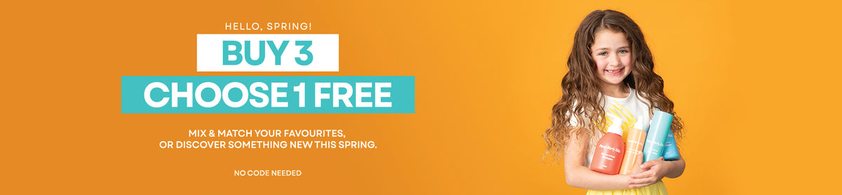 Promotional banner with a smiling girl holding two colorful bottles on the right, alongside large text reading 'HELLO SPRING! BUY 3 CHOOSE 1 FREE' and smaller offer text on a solid orange background.