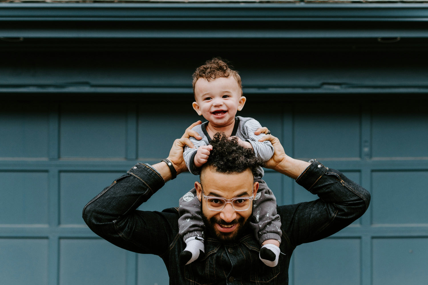 Toddler sits on man's shoulders